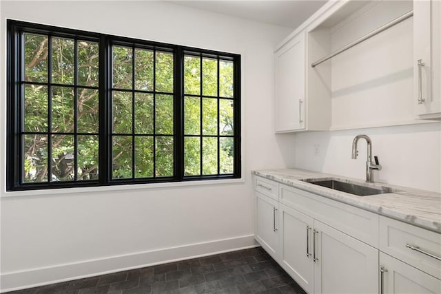 555 Orme Cir NE, Atlanta, GA 30306 - kitchen featuring a sink, baseboards, white cabinetry, and light stone counters