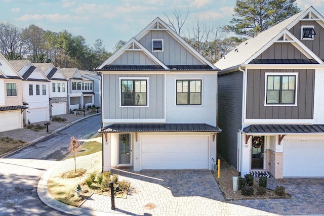 view of front of property with a standing seam roof, a garage, decorative driveway, and board and batten siding