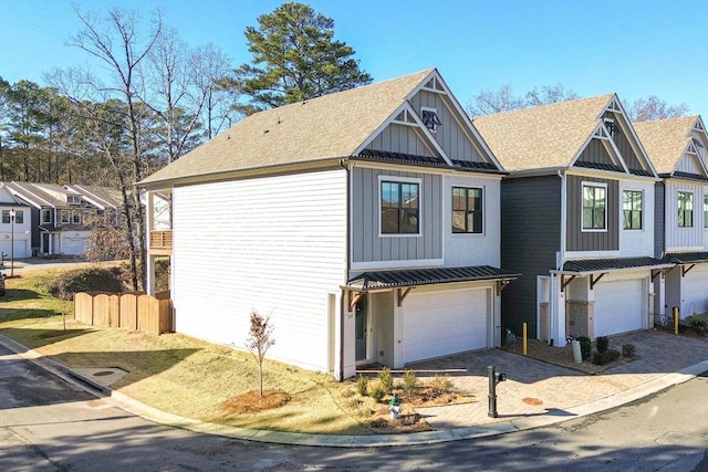 view of front of house with a standing seam roof, decorative driveway, board and batten siding, a shingled roof, and metal roof