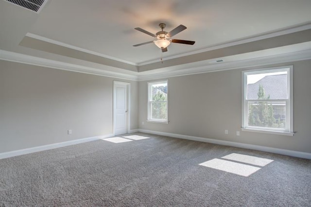 carpeted empty room with ceiling fan, a tray ceiling, and ornamental molding