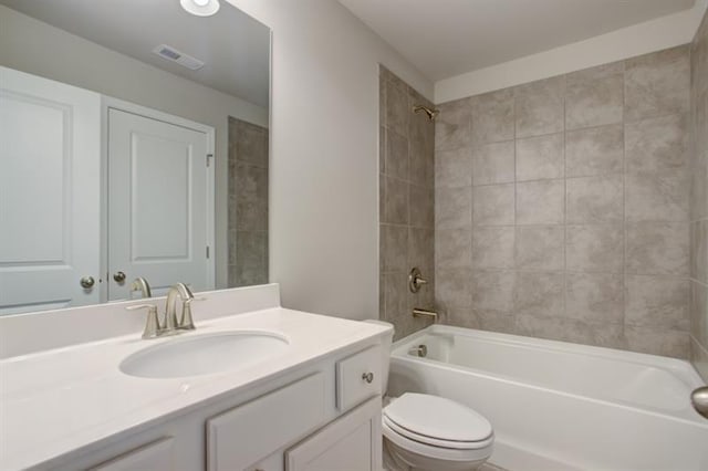 full bathroom featuring bathtub / shower combination, toilet, vanity, and visible vents