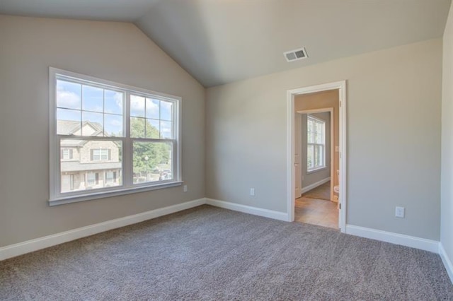 unfurnished room with vaulted ceiling and light colored carpet