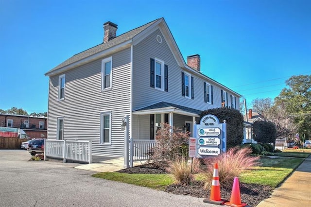 view of home's exterior with a porch and a chimney