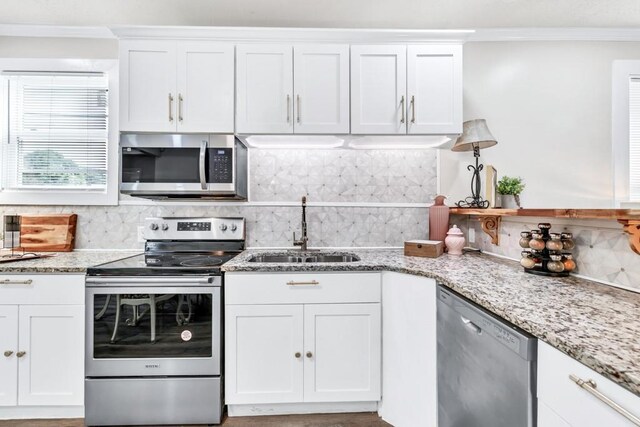 11 Poplar St, Porterdale, GA 30014 - kitchen with appliances with stainless steel finishes, a sink, tasteful backsplash, ornamental molding, and white cabinetry