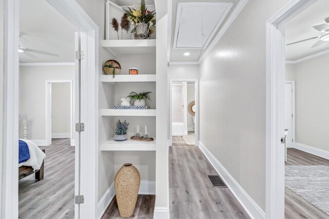11 Poplar St, Porterdale, GA 30014 - hallway with attic access, wood finished floors, built in shelves, ornamental molding, and baseboards