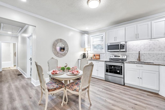 11 Poplar St, Porterdale, GA 30014 - kitchen with stainless steel appliances, a sink, backsplash, white cabinetry, and light stone countertops