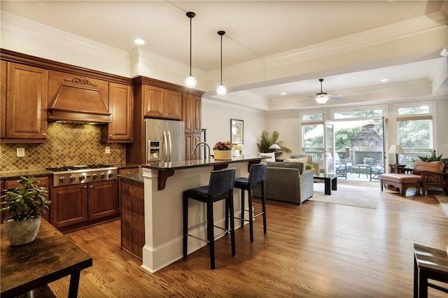 225 Mystic Ridge Hl, Sandy Springs, GA 30342 - kitchen with custom range hood, stainless steel appliances, open floor plan, wood finished floors, and a breakfast bar