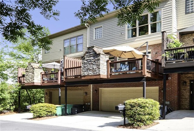 225 Mystic Ridge Hl, Sandy Springs, GA 30342 - back of house with a garage, concrete driveway, brick siding, and a deck