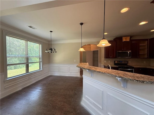 381 Plymstock Dr, Mcdonough, GA 30253 - kitchen featuring appliances with stainless steel finishes, stone counters, a decorative wall, a wainscoted wall, and hanging light fixtures