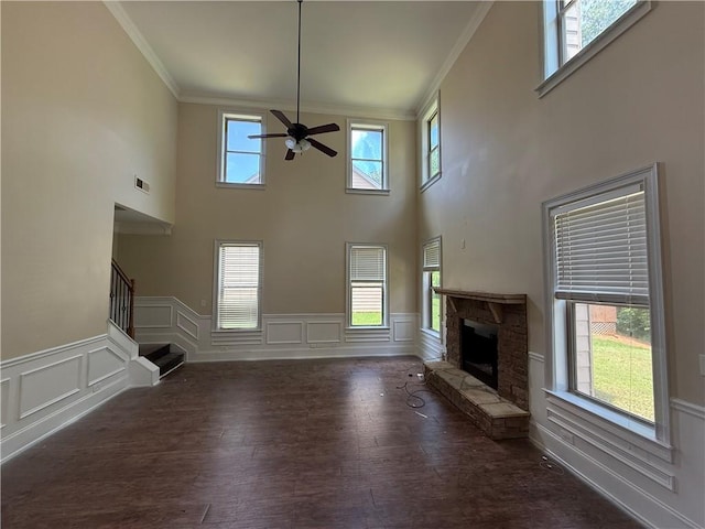 381 Plymstock Dr, Mcdonough, GA 30253 - unfurnished living room with ornamental molding, a ceiling fan, a fireplace, stairway, and a decorative wall