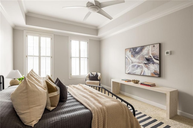 bedroom featuring crown molding, a tray ceiling, carpet flooring, and ceiling fan