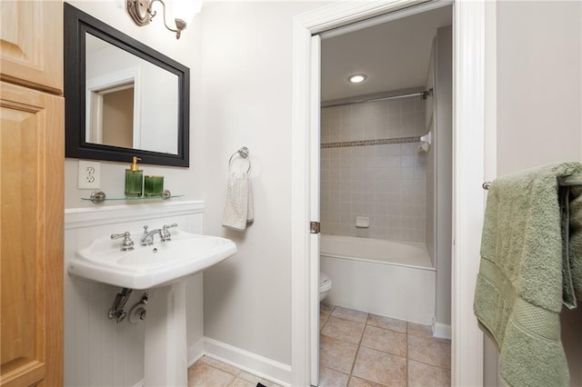 bathroom with toilet, tiled shower / bath combo, and tile patterned flooring