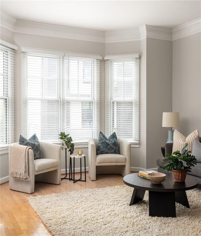 sitting room with crown molding, hardwood / wood-style flooring, and plenty of natural light