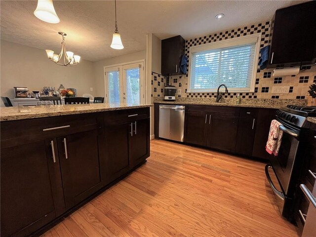 kitchen with decorative light fixtures, sink, light hardwood / wood-style floors, kitchen peninsula, and stainless steel appliances