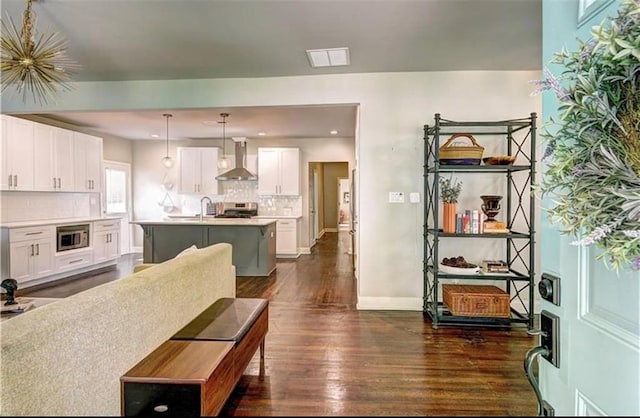 living room featuring sink, an inviting chandelier, and dark hardwood / wood-style floors