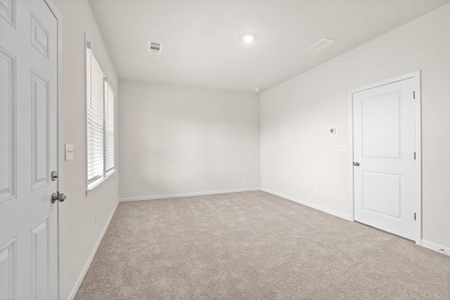 unfurnished room featuring light carpet