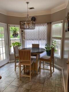 dining area with ornamental molding and a notable chandelier