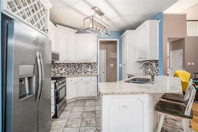 kitchen featuring white cabinets, pendant lighting, sink, appliances with stainless steel finishes, and decorative backsplash