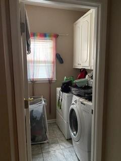 clothes washing area with washing machine and dryer and cabinets