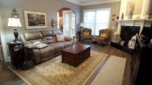 living room with a tile fireplace, ornamental molding, and dark hardwood / wood-style floors