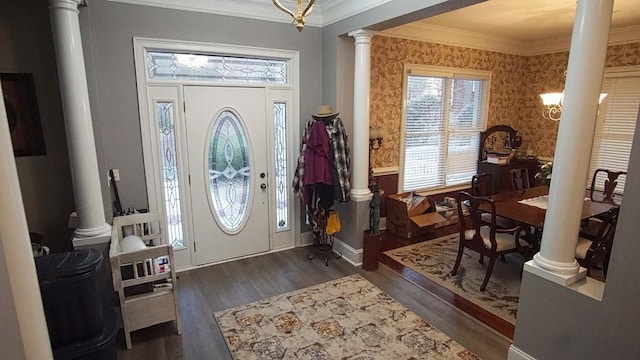 entrance foyer with crown molding, dark hardwood / wood-style floors, decorative columns, and a chandelier