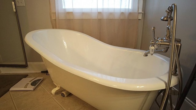 bathroom with a bath to relax in, tile flooring, and a healthy amount of sunlight