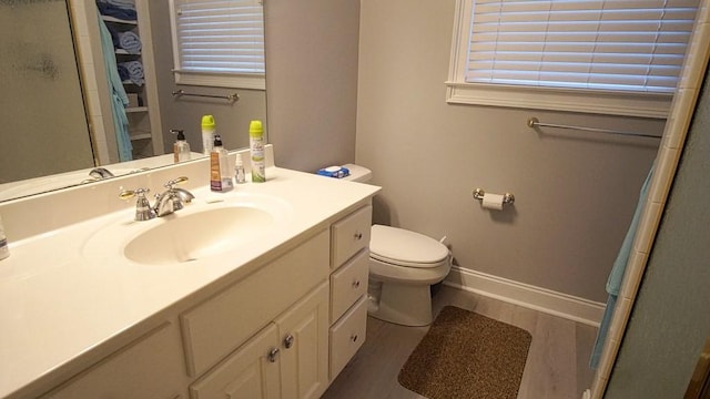 bathroom with toilet, vanity, and hardwood / wood-style flooring