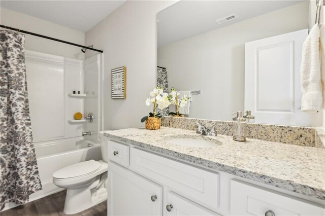 full bathroom featuring shower / tub combo with curtain, wood-type flooring, vanity, and toilet