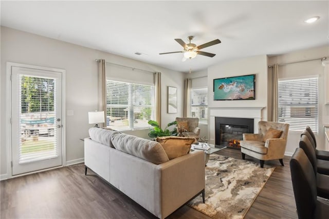 living room featuring dark wood-type flooring and ceiling fan