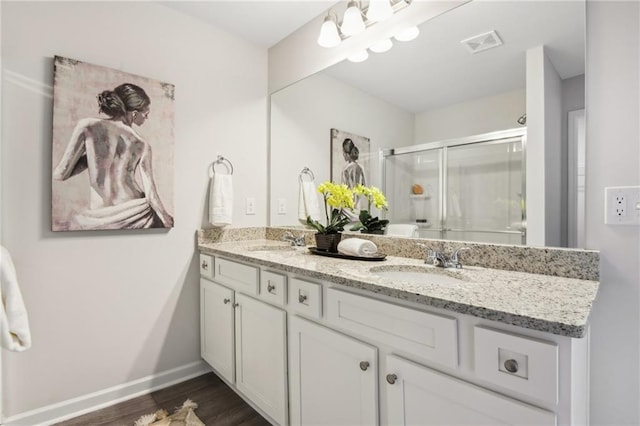 bathroom featuring hardwood / wood-style floors, walk in shower, and vanity