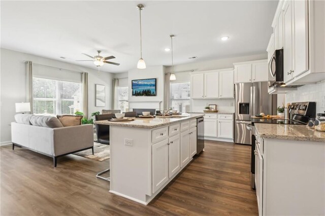 kitchen featuring pendant lighting, dark hardwood / wood-style floors, white cabinetry, and stainless steel appliances