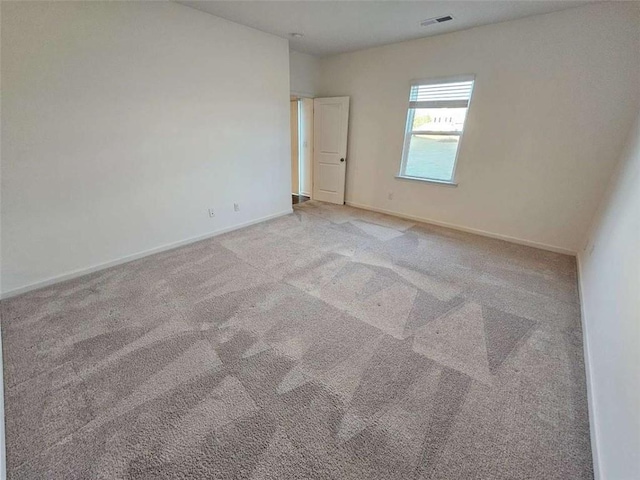 empty room with light carpet, visible vents, and baseboards