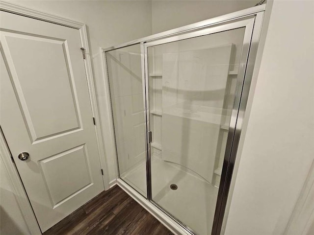 full bathroom featuring a stall shower and wood finished floors