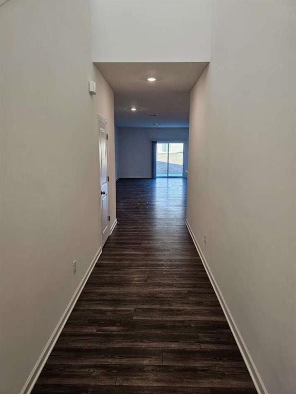 hallway featuring dark wood-style floors, baseboards, and recessed lighting