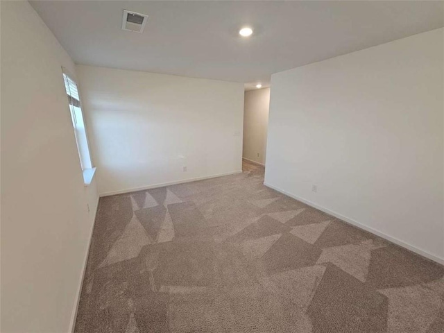 spare room with carpet, visible vents, and baseboards