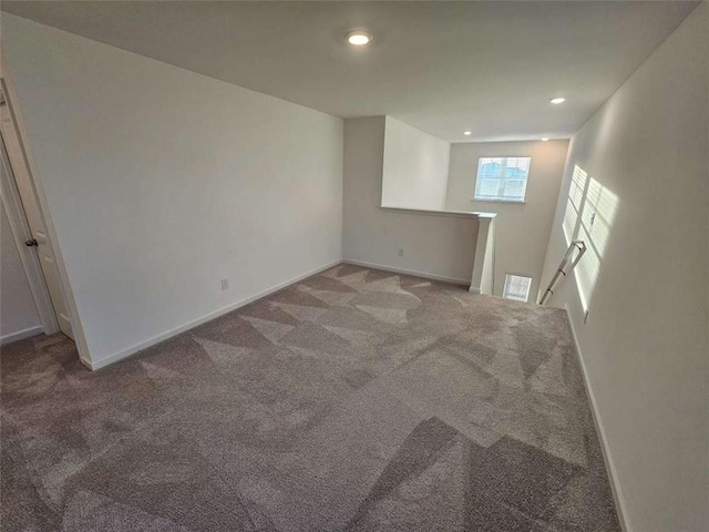 carpeted empty room with baseboards, visible vents, and recessed lighting