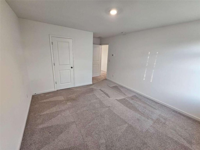 carpeted empty room with baseboards