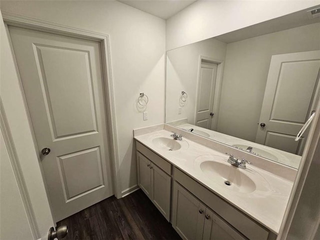 bathroom featuring wood finished floors, a sink, and double vanity