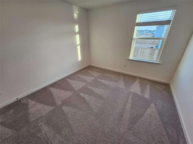 carpeted spare room with baseboards