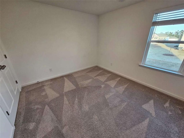 unfurnished room featuring carpet floors and baseboards