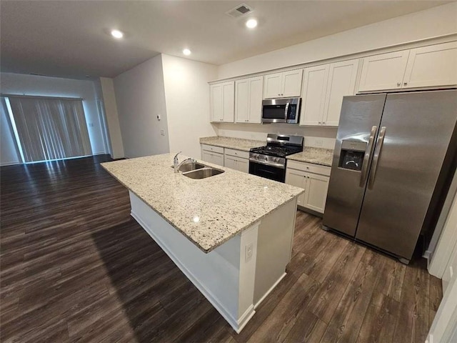 kitchen with a center island with sink, visible vents, stainless steel appliances, and a sink