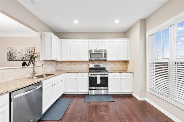 kitchen with stainless steel appliances, a sink, and light stone countertops