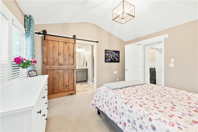 bedroom featuring light carpet, a barn door, washer / clothes dryer, an inviting chandelier, and vaulted ceiling