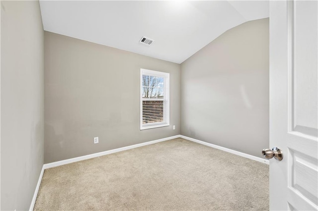 carpeted empty room with vaulted ceiling, visible vents, and baseboards