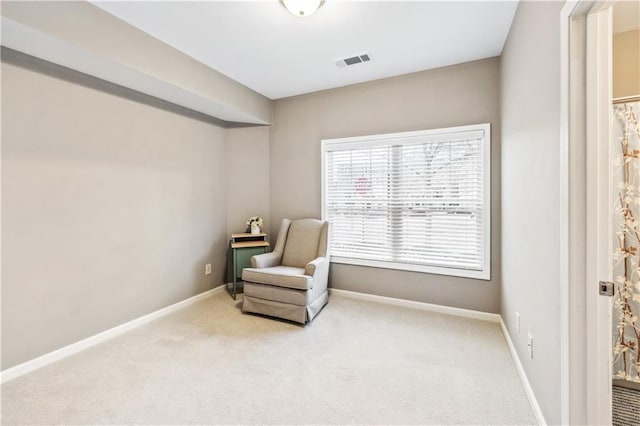 sitting room with carpet floors, visible vents, and baseboards