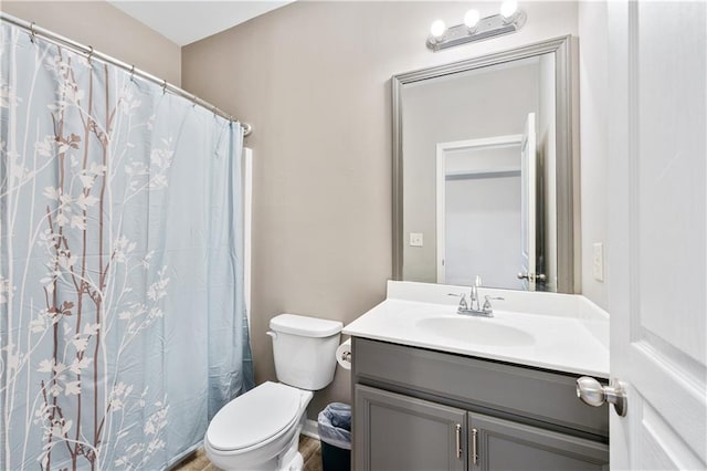 bathroom with toilet, vanity, and a shower with curtain