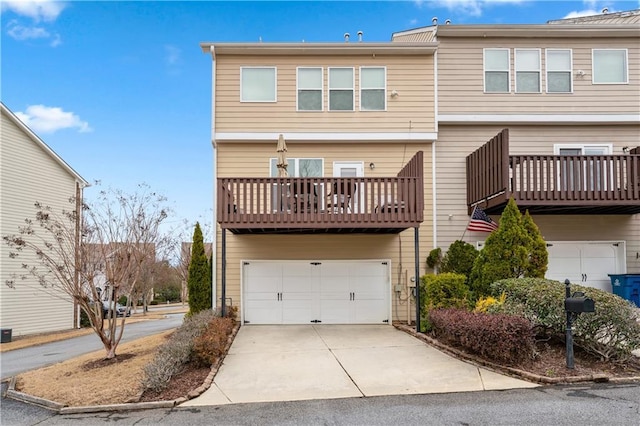 rear view of property featuring driveway and an attached garage