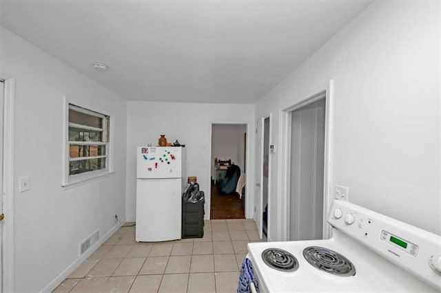 kitchen with white appliances and light tile patterned floors