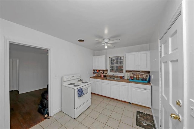 kitchen featuring electric stove, sink, decorative backsplash, and white cabinets