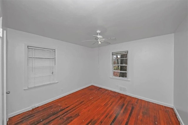 empty room with dark hardwood / wood-style floors and ceiling fan